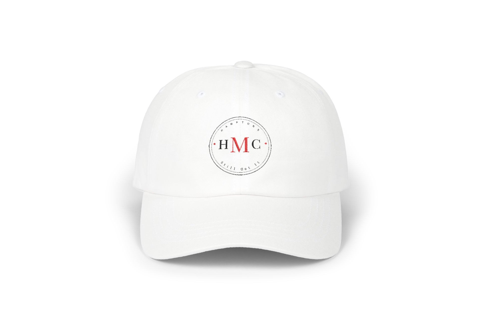 White dad cap with a black and crimson HMC Hamptons circular badge on the front